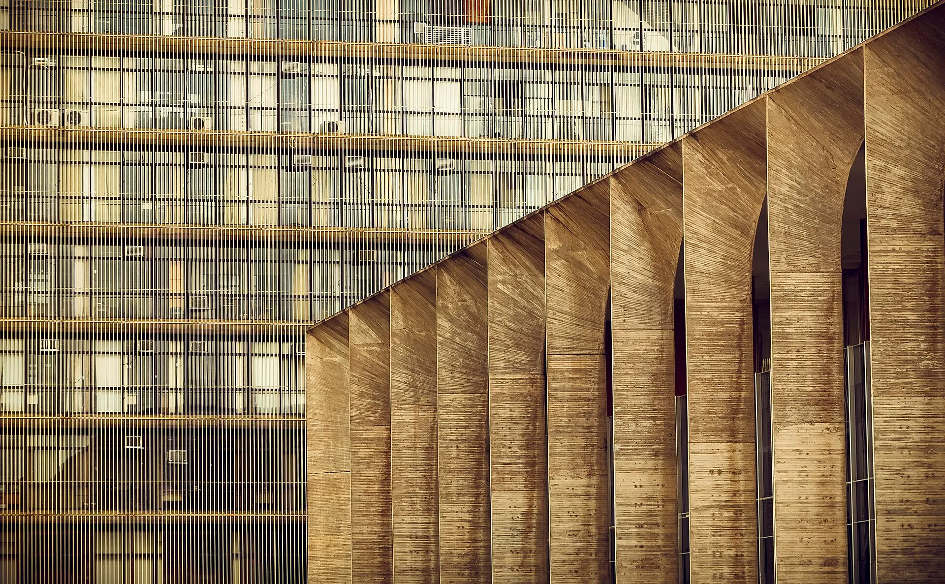 Detalhe dos arcos de concreto do Palácio do Itamaraty, em Brasília, diante da fachada gradeada do edifício anexo.