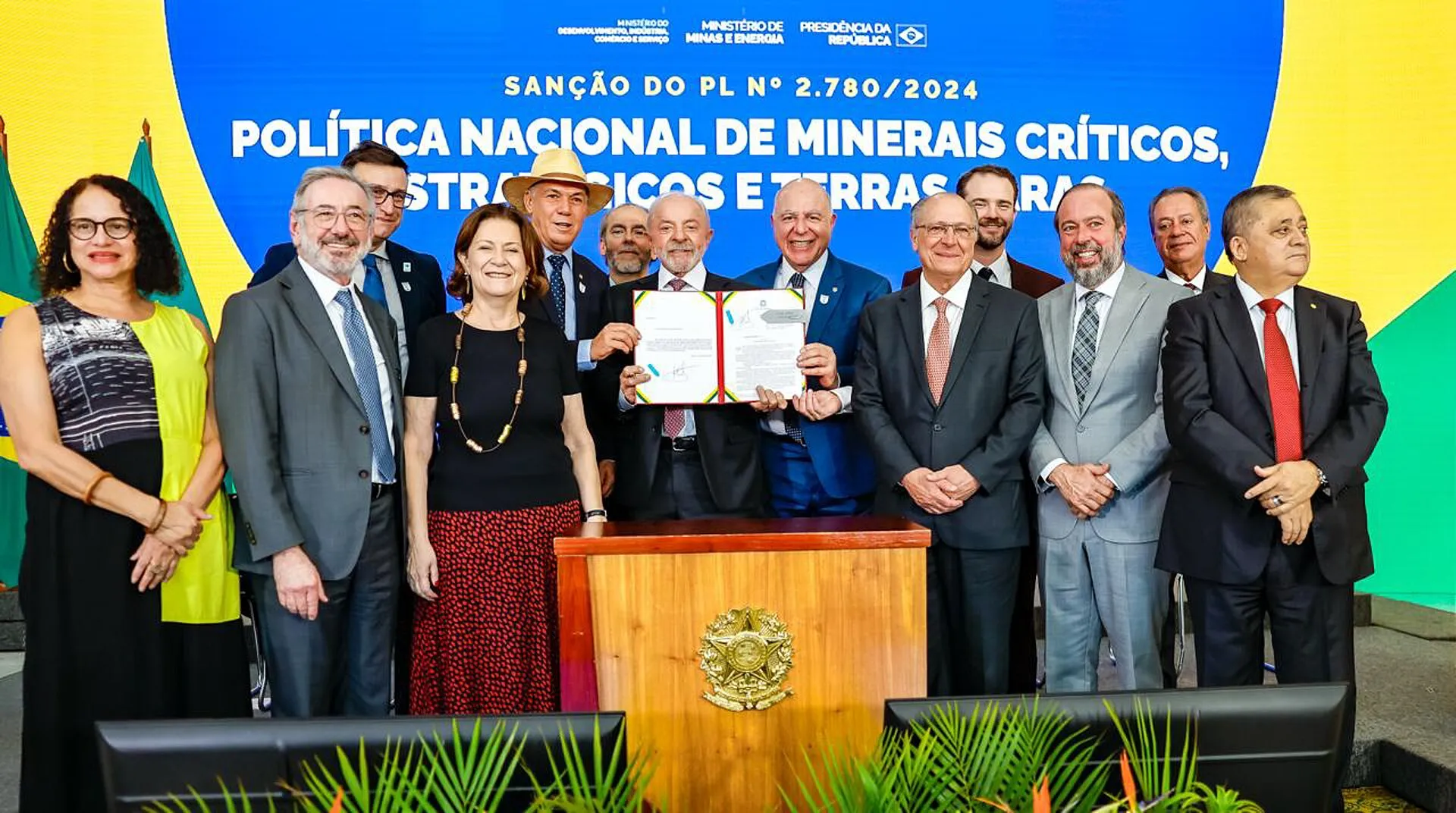Lula segura o documento da sanção em cerimônia no Palácio do Planalto, diante de painel com o título da política de minerais críticos.